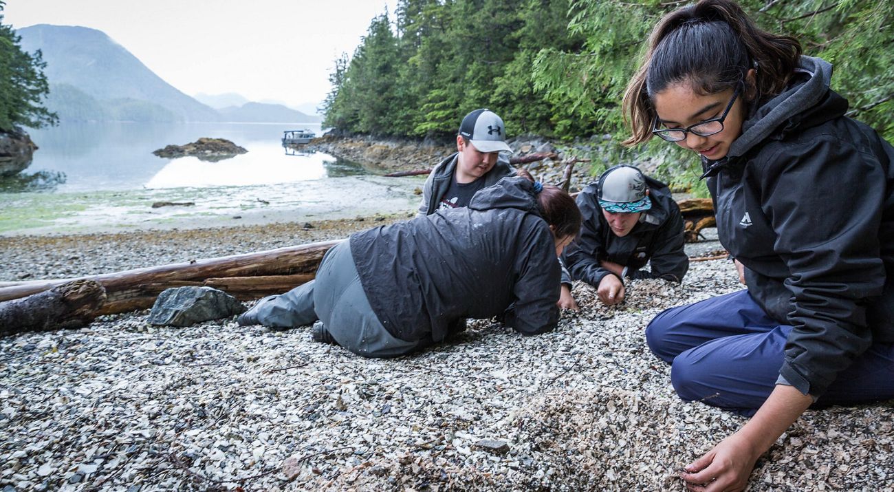 four teens on a rocky beach