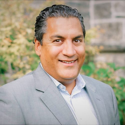 Headshot of Sasha Jacob smiling in a suit