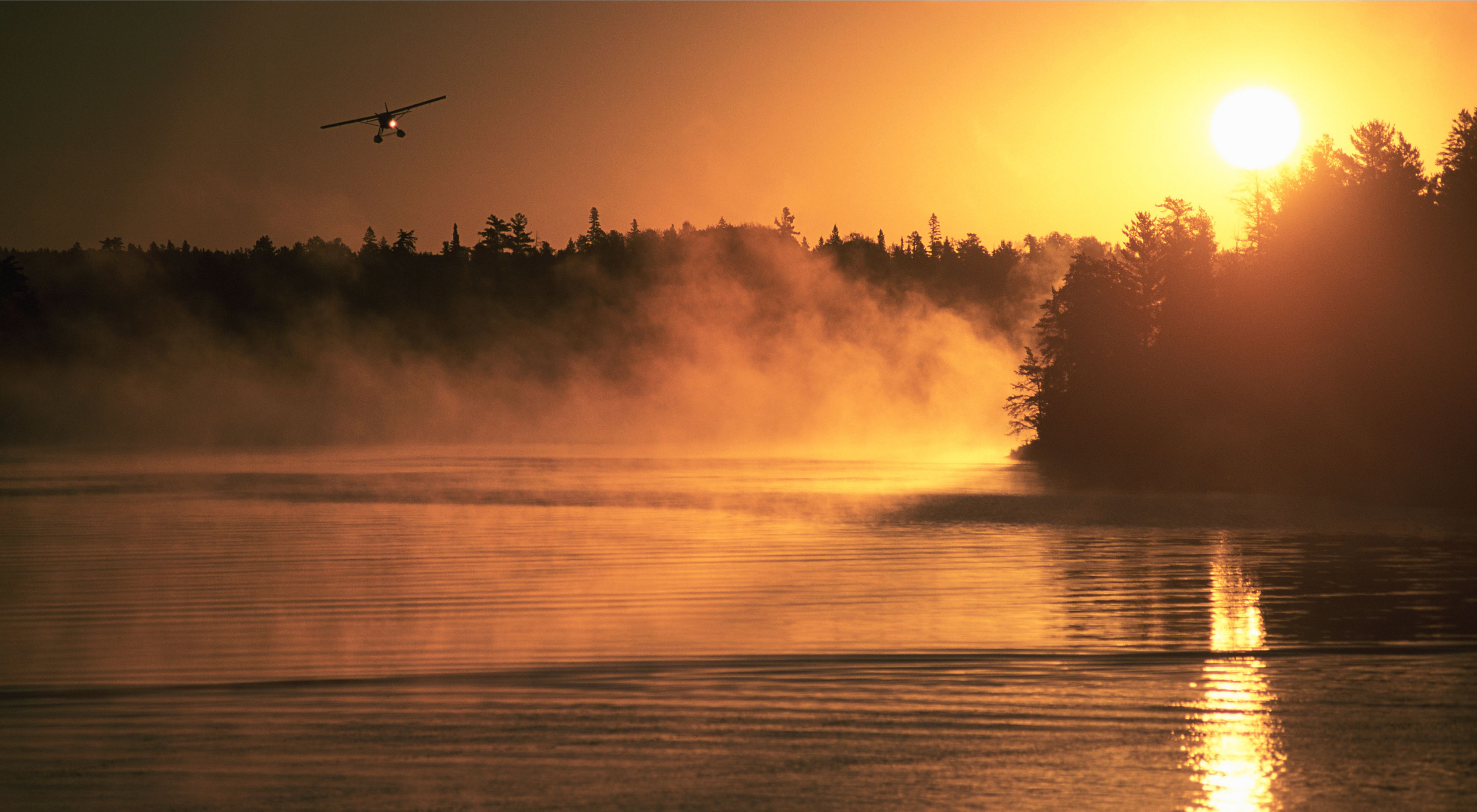 A float plane carrying fishermen departs at dawn from Nestor Falls on one of the many lakes in the Lakes of the Woods region of Ontario Canada.