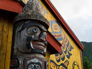 a totem pole in front of the big house in Klemtu, BC