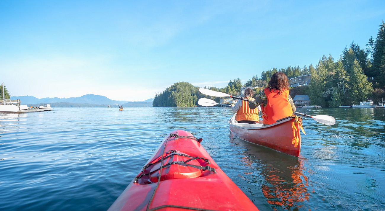 A canoe with two people in it makes its way through the water in British Columbia.