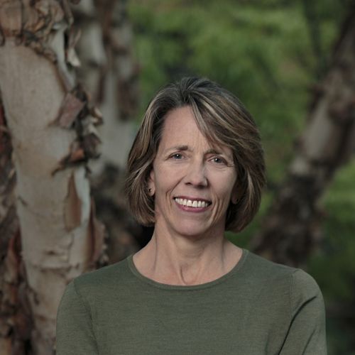 a woman with short gray hair in a green shirt