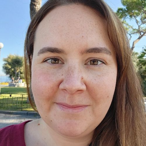 headshot of a woman in a white shirt holding a puppy
