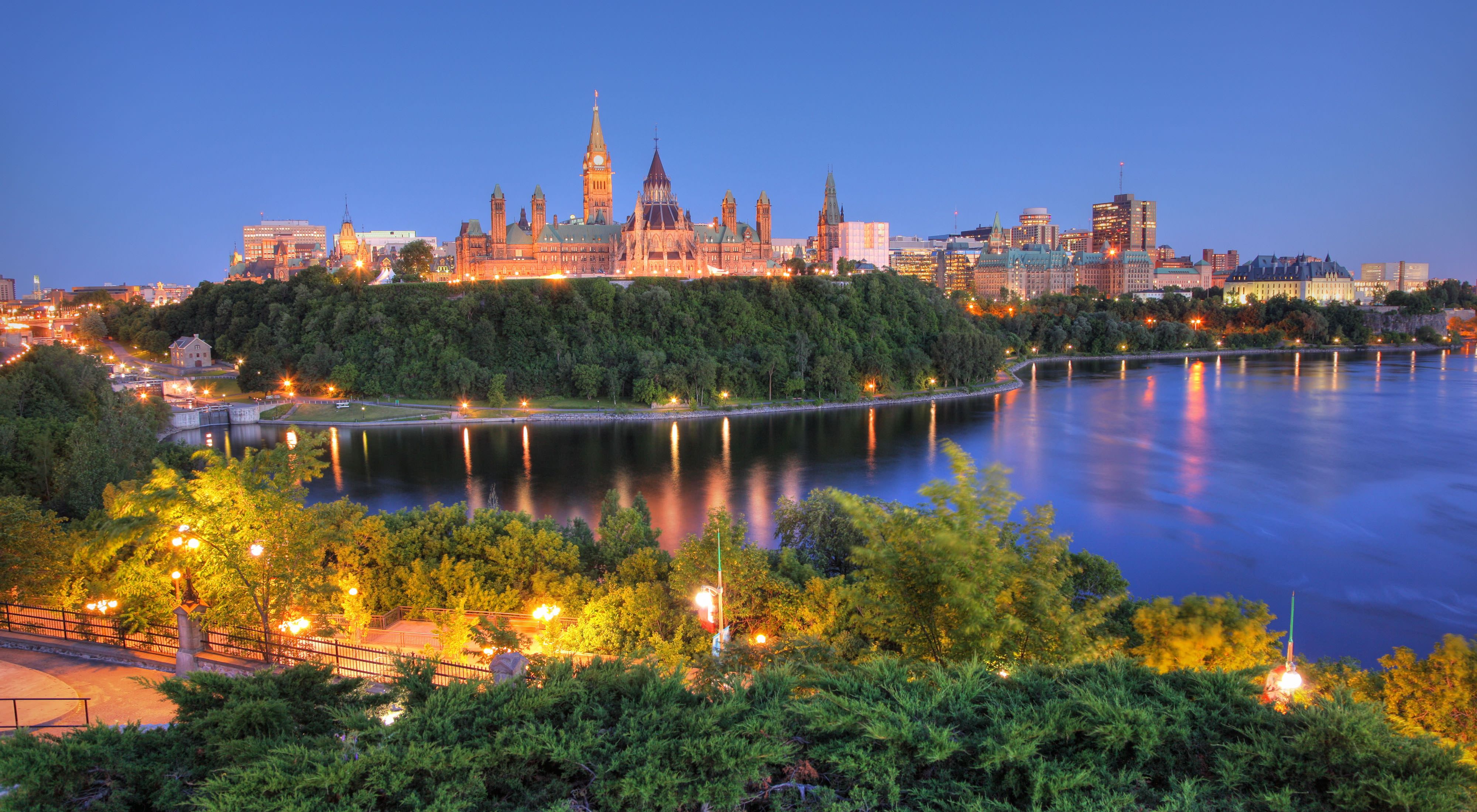 Canada's capital building lit up at night and surrounded by trees in Ottawa, Ontario.