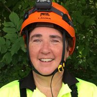 headshot of a woman in a yellow safety vest and an orange helmet