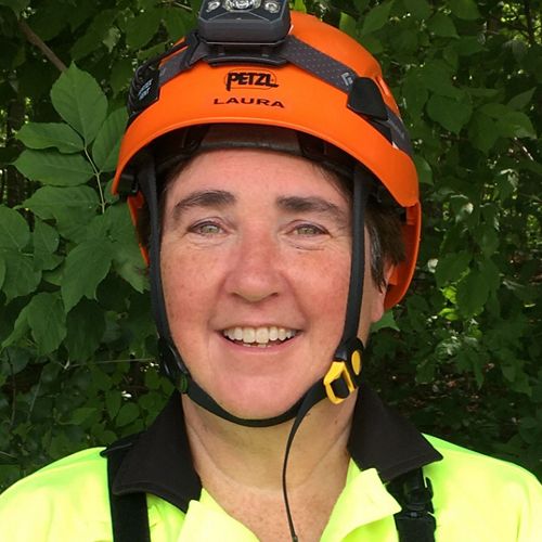 headshot of a woman in a yellow safety vest and an orange helmet