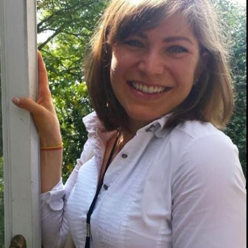 headshot of woman in white shirt with brown hair