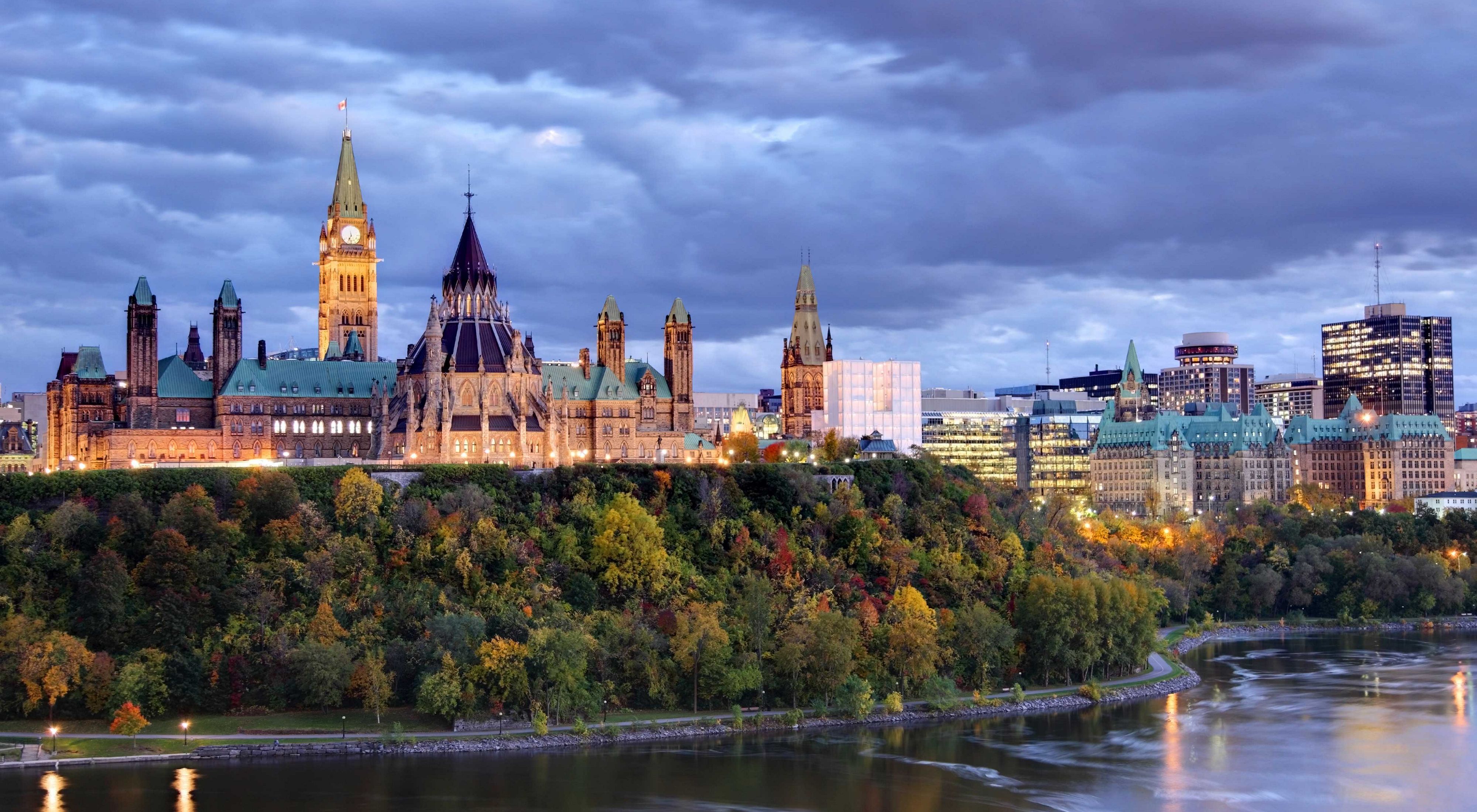 Parliament Hill atop a dramatic hill overlooking the Ottawa River in Ottawa, Ontario in autumn.