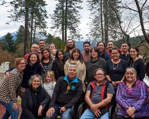 a group of people pose for a photo in front of a barn