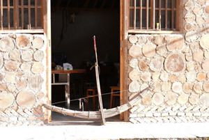 A giant bamboo crossbow rests against the doorway of a building.