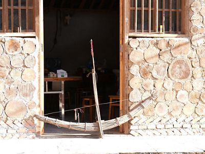A giant bamboo crossbow rests against the doorway of a building.