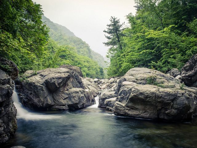 The Old Creek River navigates its way among giant boulders at the bottom of steep, densely forested valleys in Laohegou Nature Reserve, Pingwu County, Sichuan Province, China.