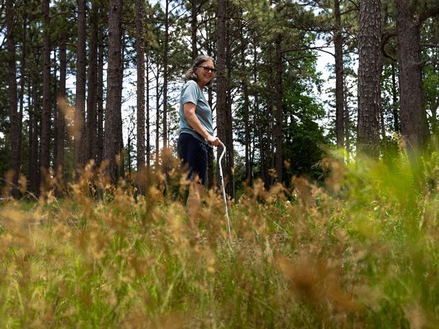 Woman poses in forest for photo.