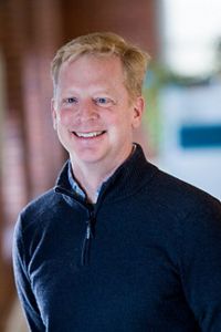 Dan Coker smiles in a portrait.