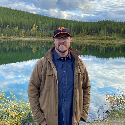 Person standing in front of lake.
