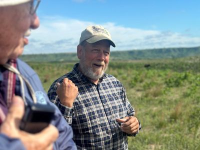 David talking with rolling hills in background