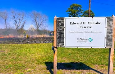 A small fire burns behind a preserve sign.