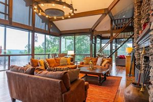 Large living room surrounded by windows.