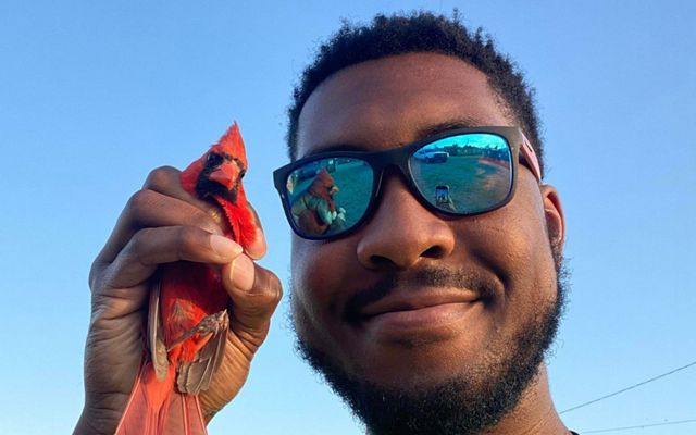 Derrick Mason holding a cardinal.