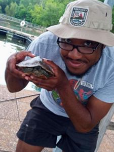 Photo of Derrick Mason holding a turtle.