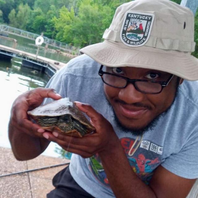 Photo of Derrick Mason holding a turtle.