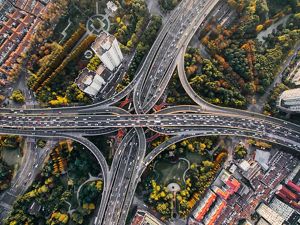 Aerial view looking down on a cloverleaf intersection of highways with many cars on the roads.