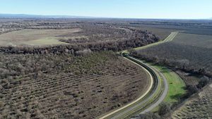 Aerial view of a winding road cutting through agricultural lands.