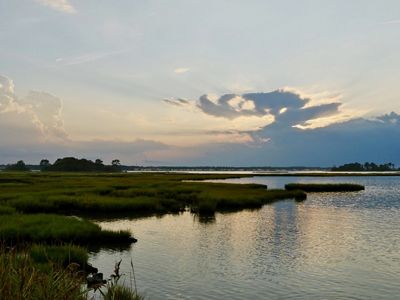 The sun sets over calm waters.