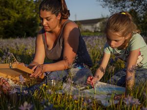 Kenison beside 6-year-old girl paint in field of flower