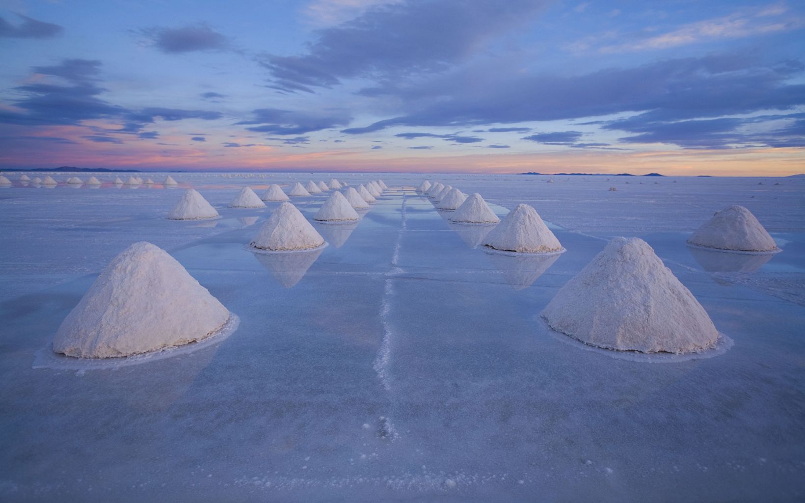 Salt of the Earth Piles of salt awaiting transport to a processing plant dot the Salar de Uyuni on the high plains of the Bolivian Andes. © George Steinmetz