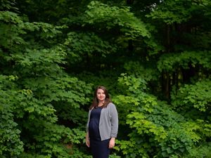 Un retrato de Teresa Pershing delante de árboles verdes frondosos.