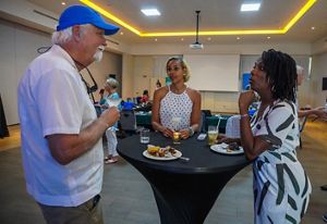 Three people converse over drinks and food.