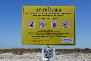 A large yellow sign on Smith Island warns visitors of sensitive nesting areas nearby.