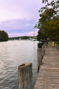 A wooden boardwalk sits along side a river.