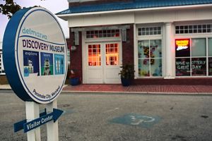 A round sign with "discovery center" written points to a building behind it. 