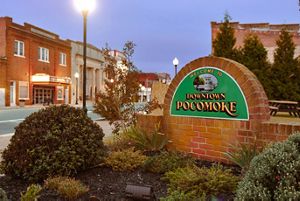 A brick sign in front of a road welcomes people to Pocomoke City.