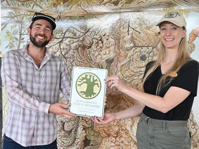 Two people hold a certificate and smile for the camera.
