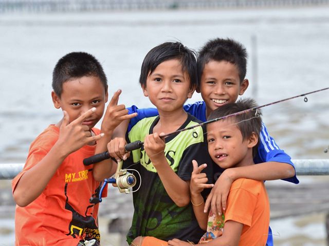 Children fishing on a pier in Indonesia