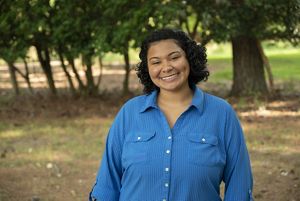 Basia Scott headshot. Virginia marketing intern Basia Scott poses outside on the grounds of VVCR's Brownsville Preserve.