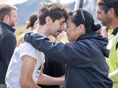 Two people embrace with foreheads and noses pressed together.