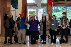 Several people stand in a line with animated faces and hands.