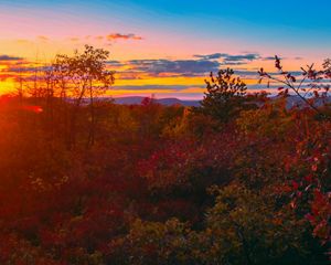 A sunsets over the horizon creating a pink, purple, and orange clouded sky.