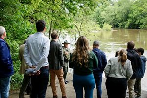 A group of people gather along a river.