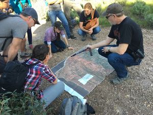 Visitors look down at a map of the Dangermond Preserve on the ground.