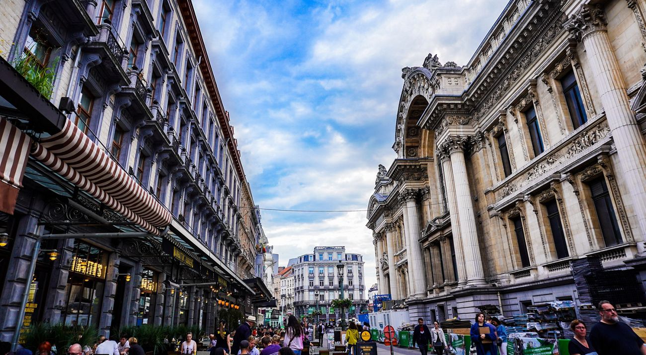 Busy city street of Brussels with surrounding buildings and people walking