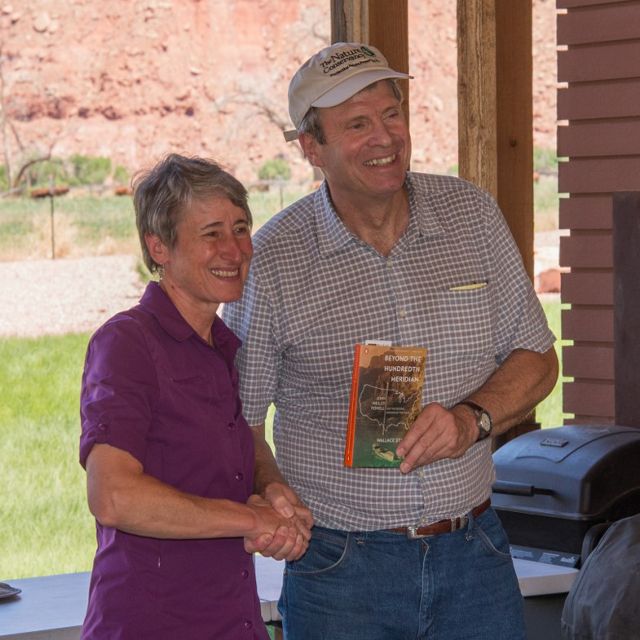 Sally Jewell shaking hands with Dave Livermore, who's holding a book.