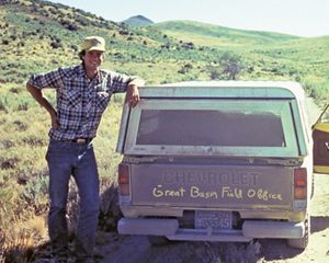 Dave Livermore standing next to truck on a dirt road in a desert landscape.