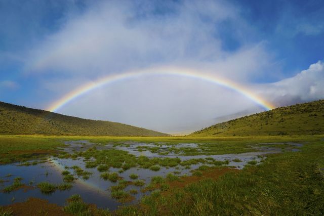 High andean wetland with a rainbow on the horizon.
