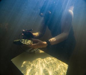 A woman takes measurements underwater.