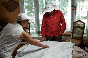 Two women look over a map spread out on a table.